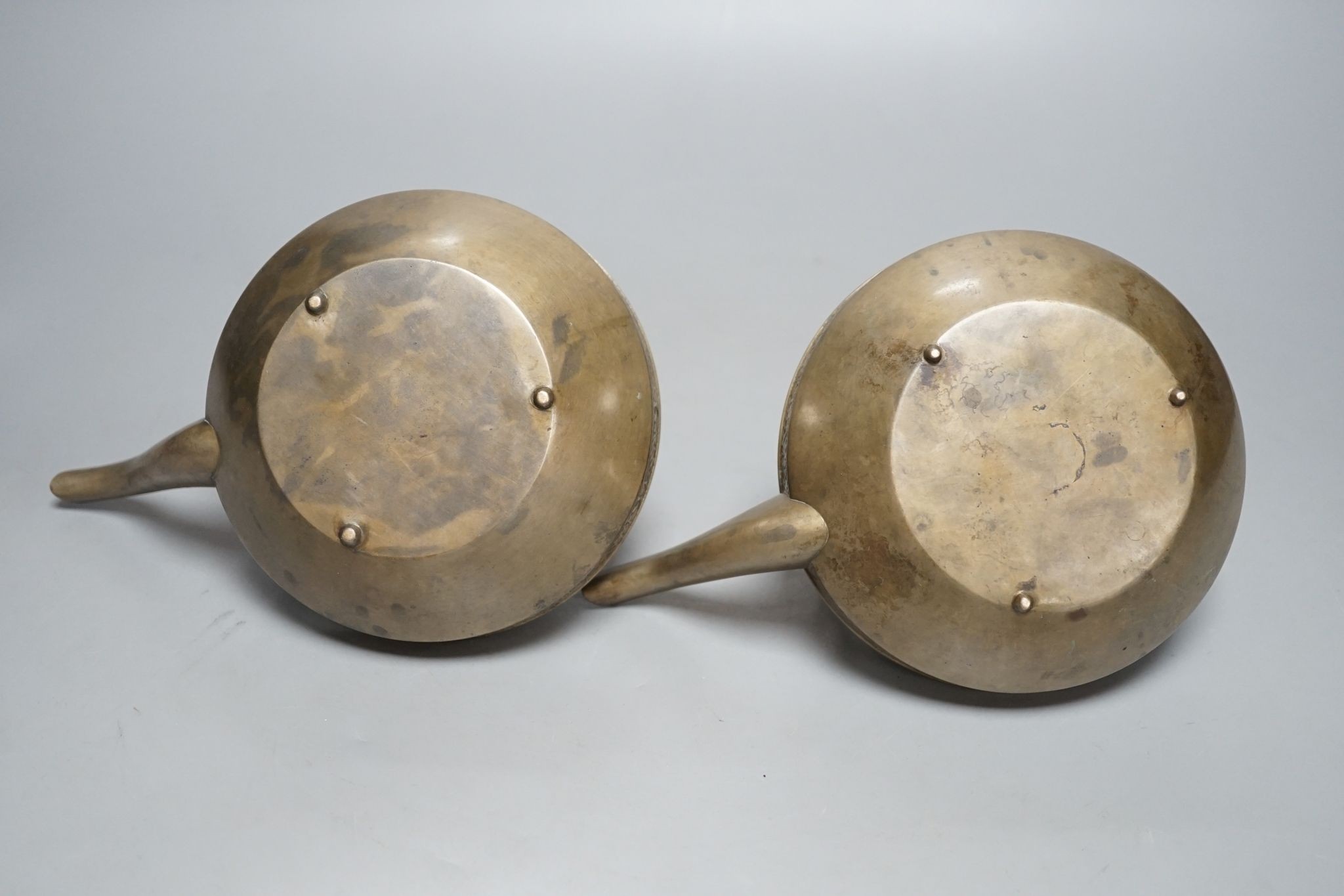 A pair of bronze teapots